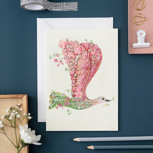 Artistic bird card with floral details on a desk with stationery.