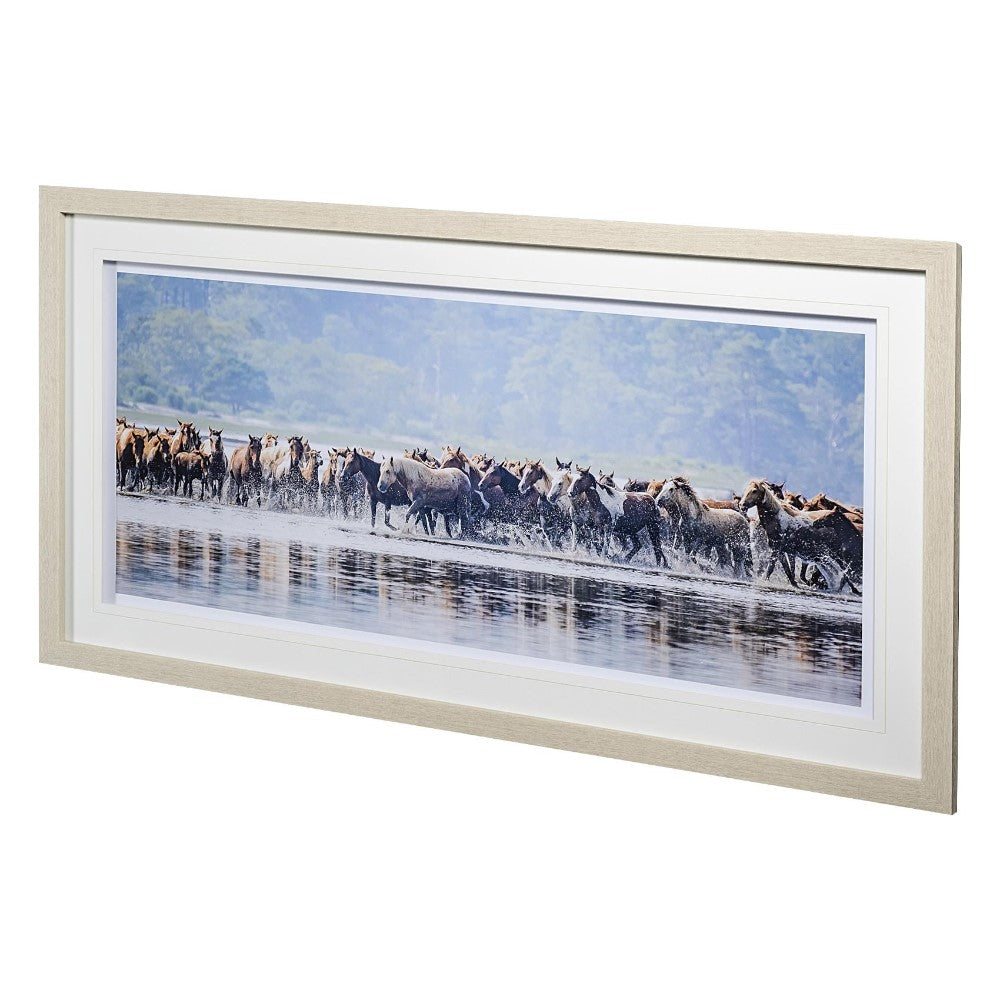 Framed photo of running horses in shallow water and scenic background.