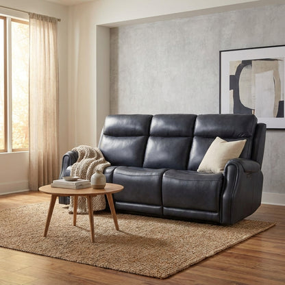 Cozy living room with a dark sofa, knit throw, and round coffee table.