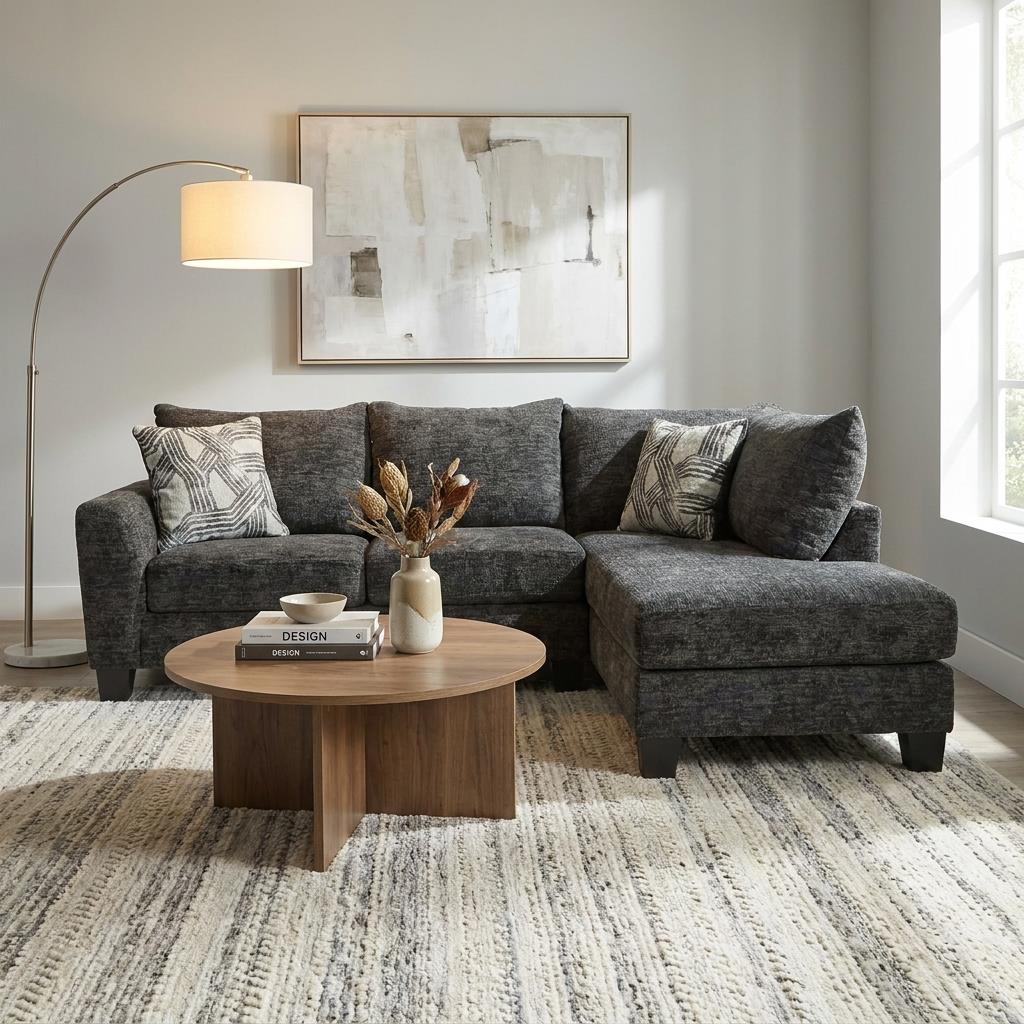 Cozy living room with a dark gray sofa, round table, and abstract art.