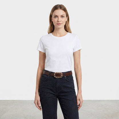 Woman in white T-shirt and jeans against a plain background.