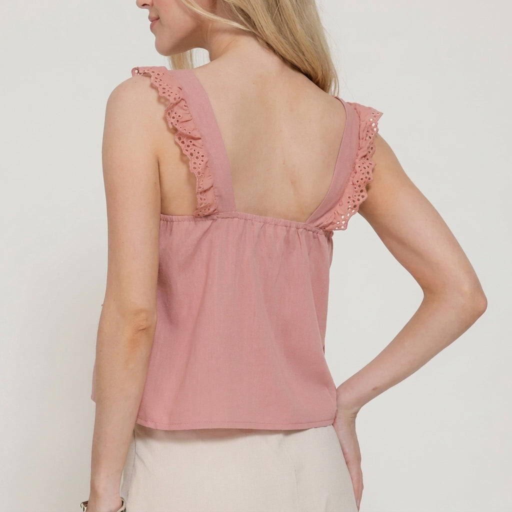 Woman in pink sleeveless top with lace details, showing back view.