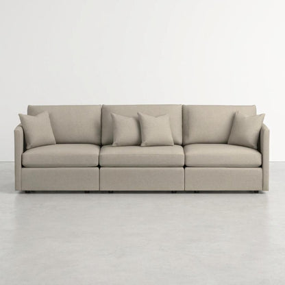 Modern beige sofa with matching cushions on a white background.