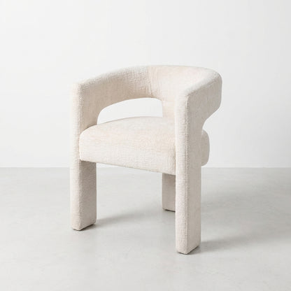 Modern white boucle chair with curved back.