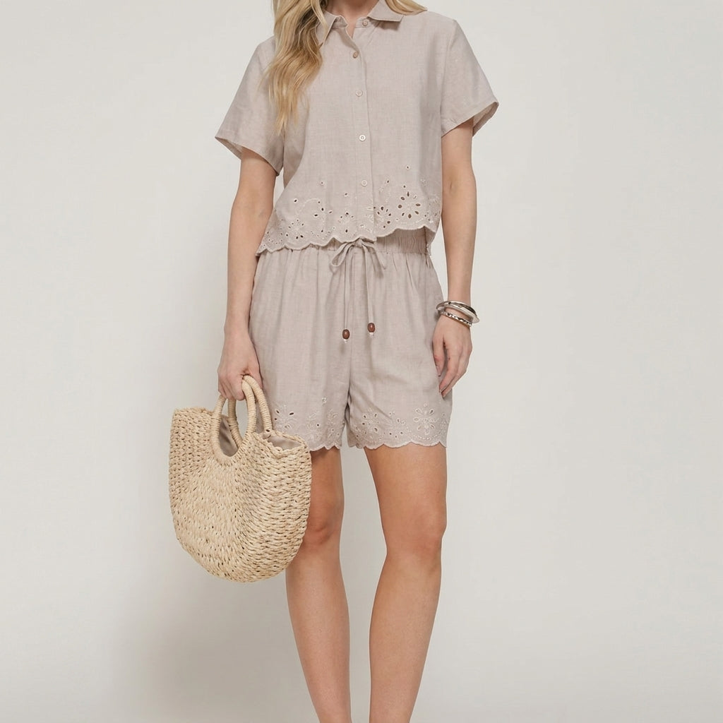 Woman in a beige outfit holding a woven bag.