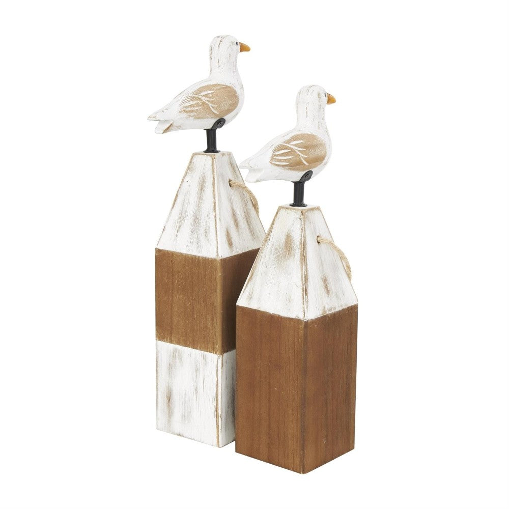 Wooden seagulls perched on rustic wooden posts.