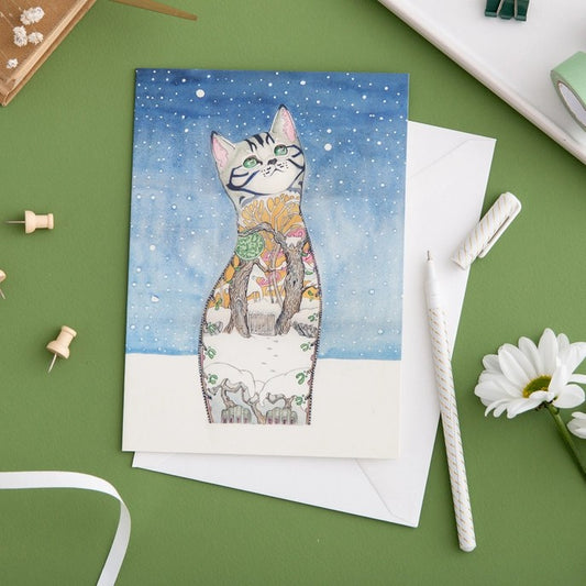 Artistic cat illustration on a card with a nature-themed design.