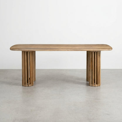 Wooden table with rounded edges and cylindrical legs.