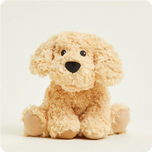 Fluffy beige plush puppy with floppy ears sits on a light background.