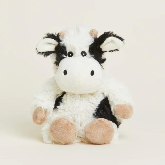 Fluffy cow plush toy with a cute face and black and white pattern.