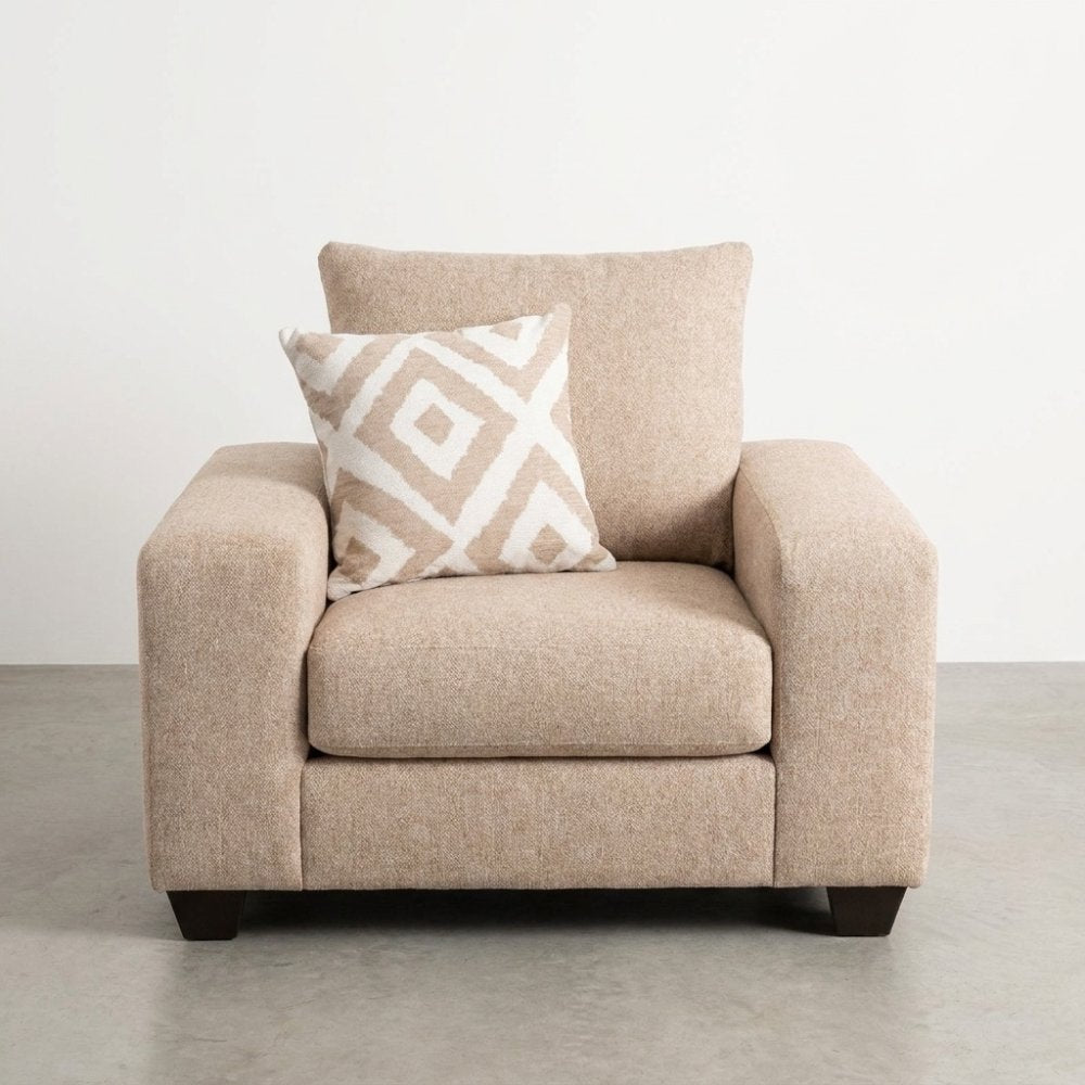 Beige armchair with patterned cushion on a concrete floor.