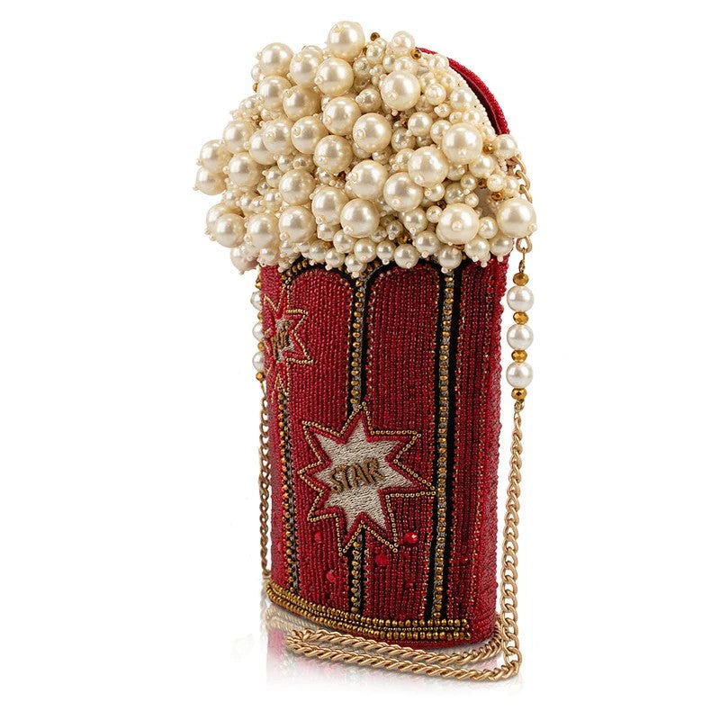 Popcorn-shaped clutch with pearl embellishments and gold chain over a starry red base.