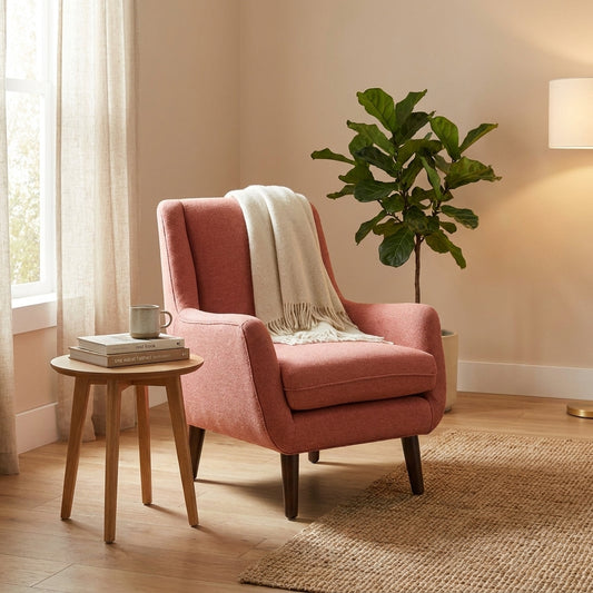 Modern pink armchair with tapered wooden legs.