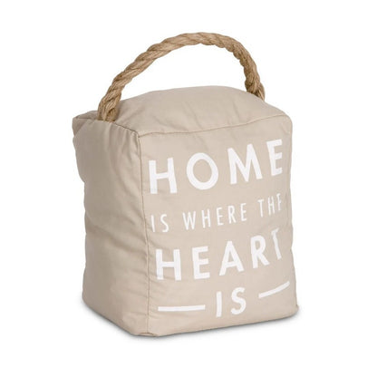 Beige doorstop with rope handle, "Home is where the heart is" text.