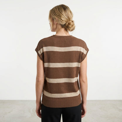 Person in brown striped top with hair in a bun, seen from the back.
