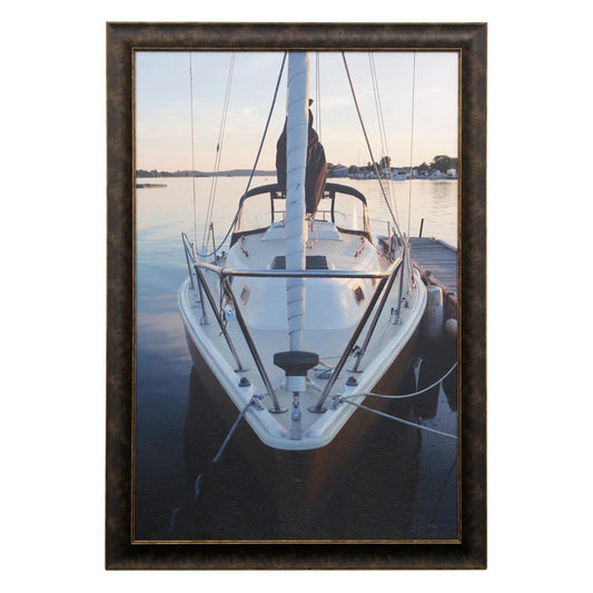 Sailboat docked in serene waters at sunset, framed.