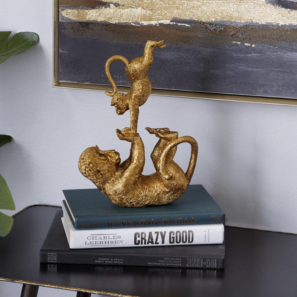 Golden monkey sculpture balancing on books.