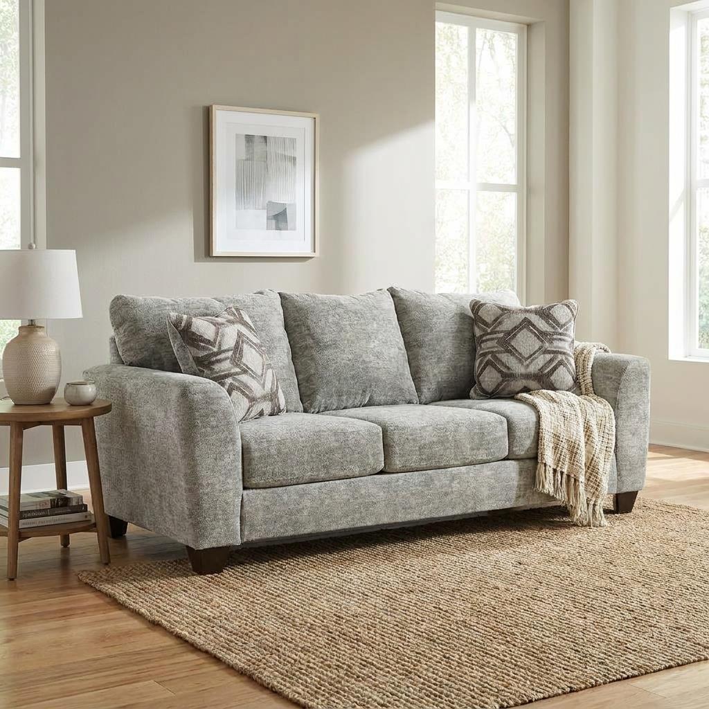 Gray sofa with pillows and a throw blanket in a bright room.
