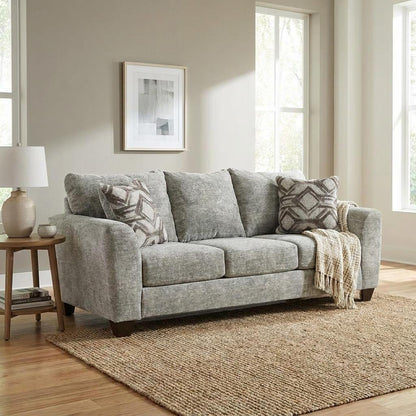 Gray sofa with pillows and a throw blanket in a bright room.