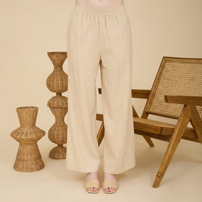 Beige pants and woven decor in a minimalist setting.