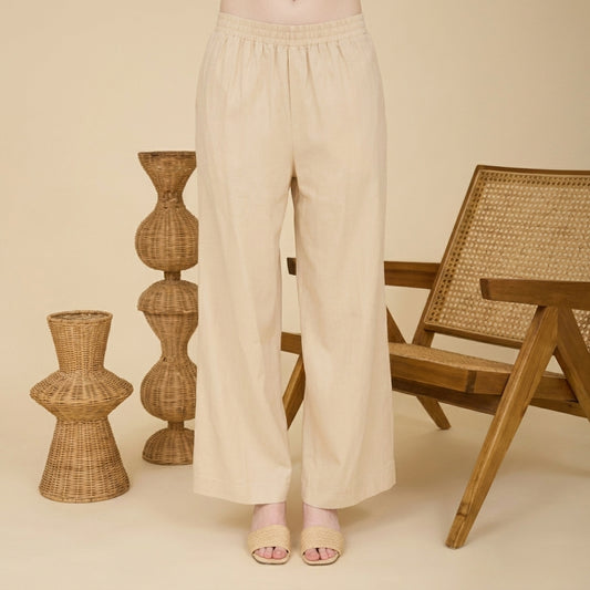Beige pants and woven decor in a minimalist setting.
