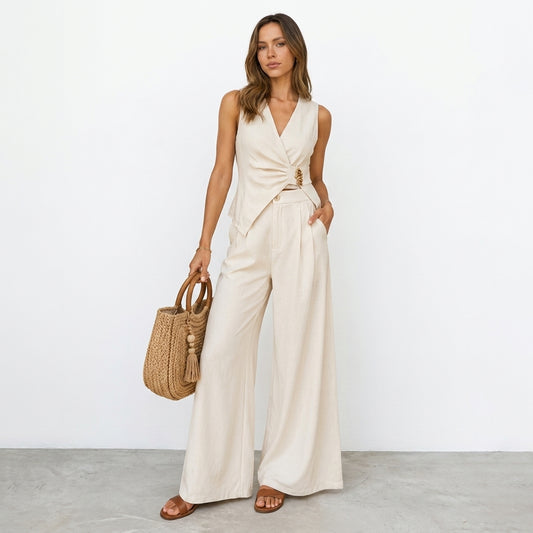 Woman in beige outfit with woven bag, standing against a white background.