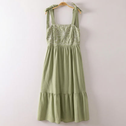 Green dress with floral embroidery and tied shoulder straps.