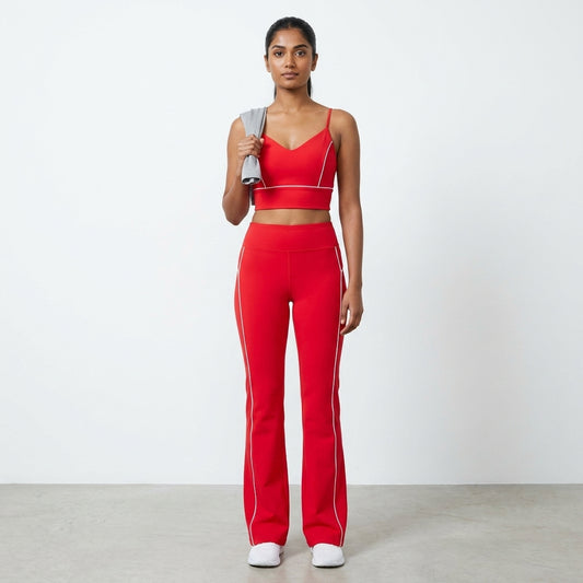 Woman in red sports outfit holding a gray resistance band.
