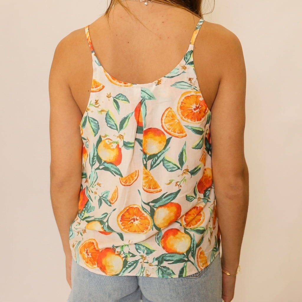 Back view of a citrus print tank top and light blue jeans.