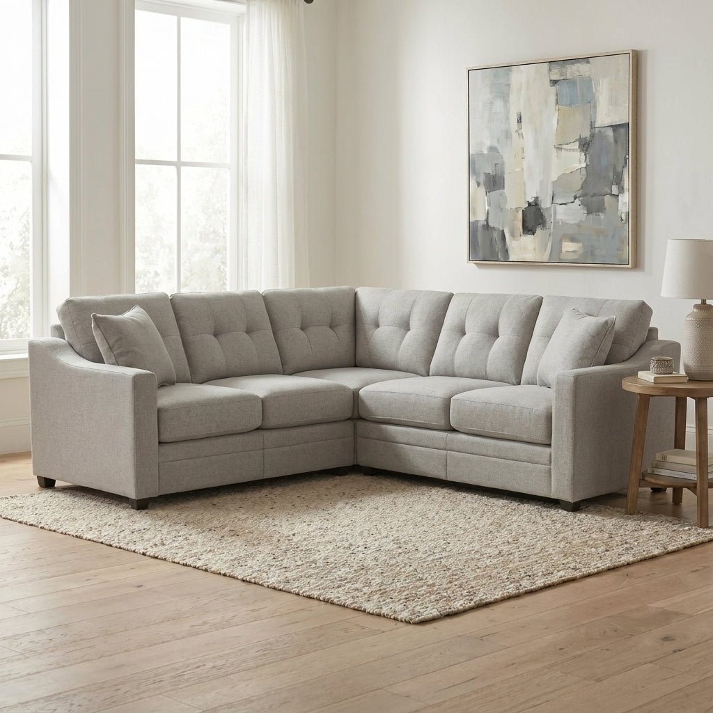 Gray sectional sofa in a bright living room with abstract art and wooden floor.