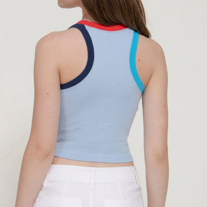 Person in a colorful tank top and white pants, viewed from the back.