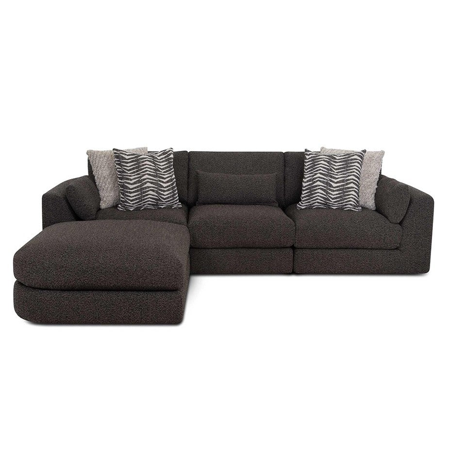 Dark L-shaped sofa with patterned pillows.