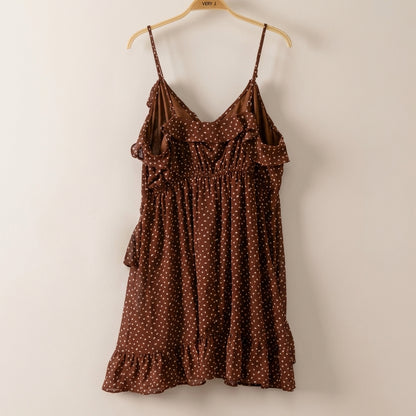 Brown polka dot dress with ruffled neckline and hem, on a hanger.