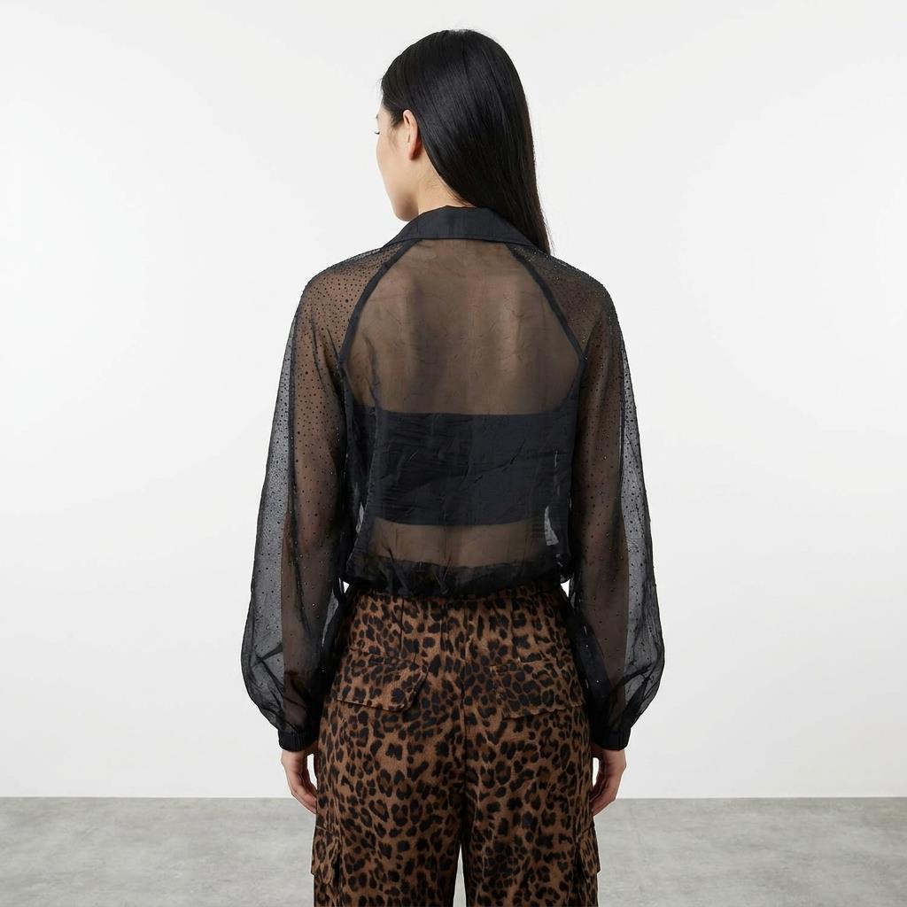 Person in sheer black top and leopard print pants, back view.