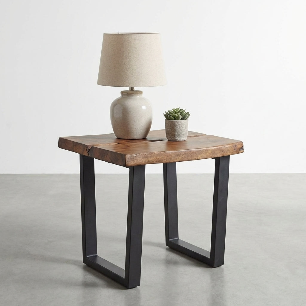 Wooden side table with lamp and potted succulent on concrete floor.