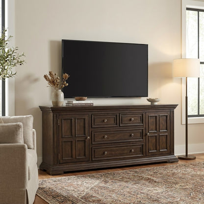 Living room with TV, wooden console, sofa, and lamp.