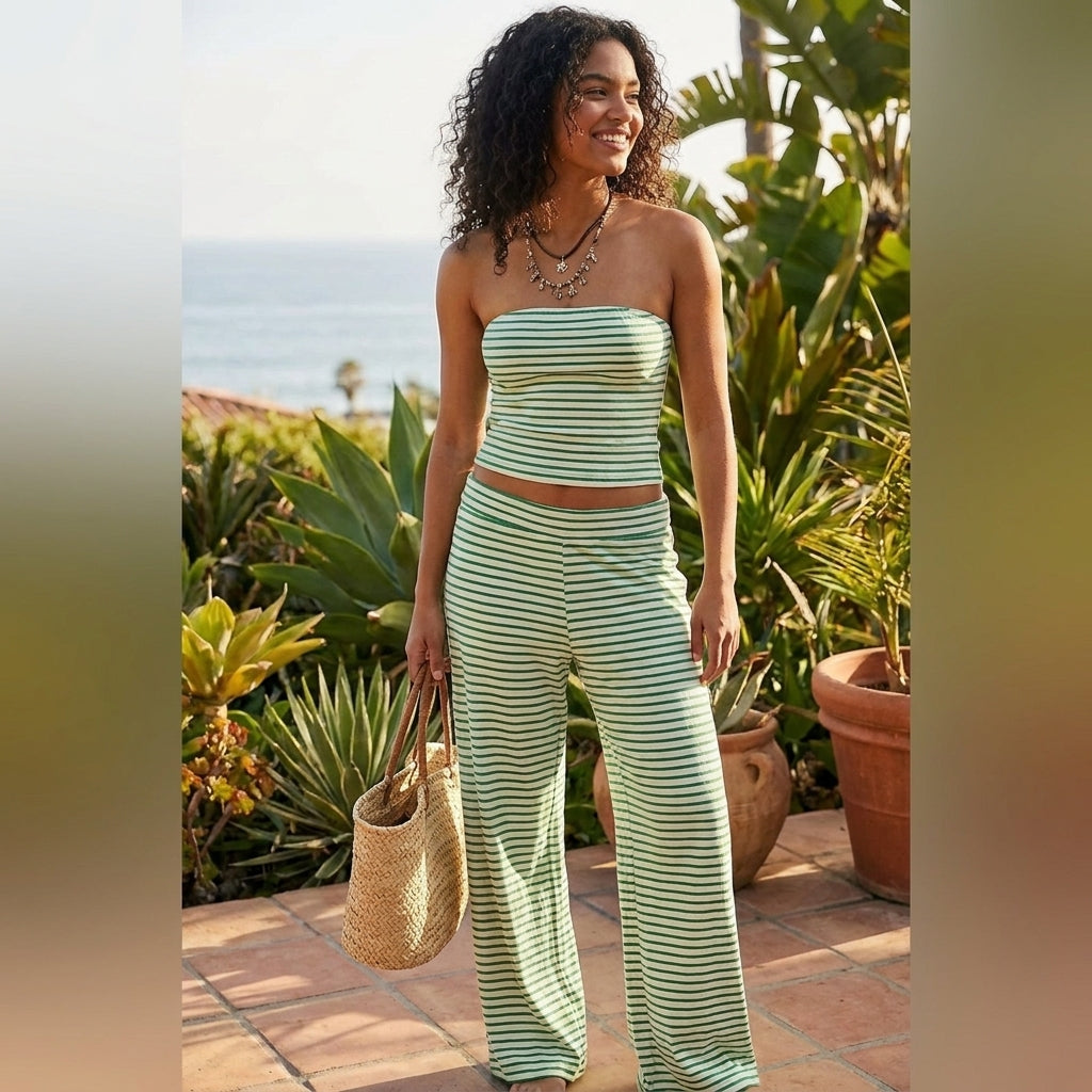 Woman in striped outfit with a straw bag by the beach.