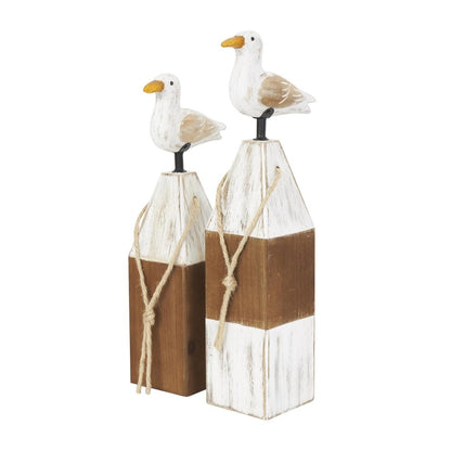 Wooden seagulls on painted lighthouse sculptures.
