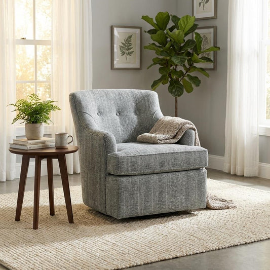 Cozy room with a gray armchair, table, and plant near sunlit windows.