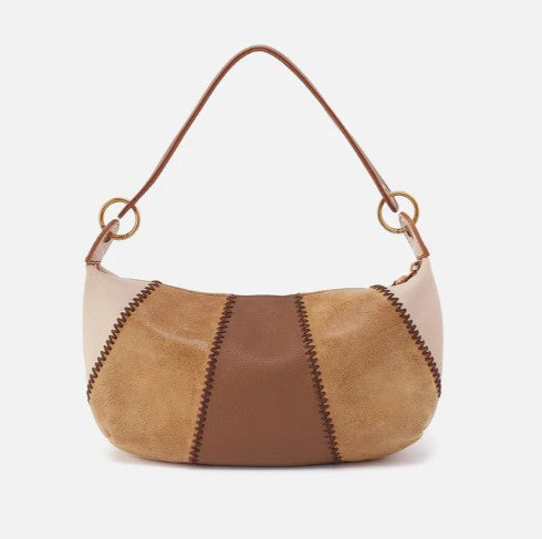 Brown and beige patchwork hobo bag with a curved handle and gold rings.