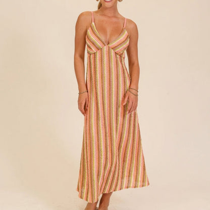 Smiling woman in a colorful, striped summer dress.