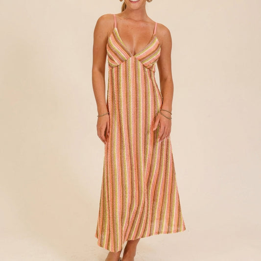Smiling woman in a colorful, striped summer dress.