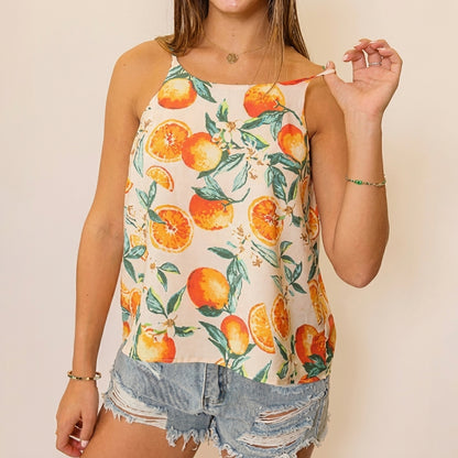 Woman wearing a citrus-patterned top and denim shorts.
