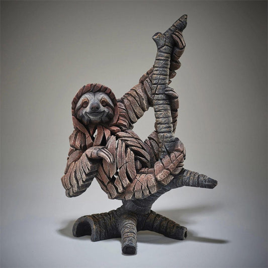 A whimsical sloth sculpture made from stone-like materials.