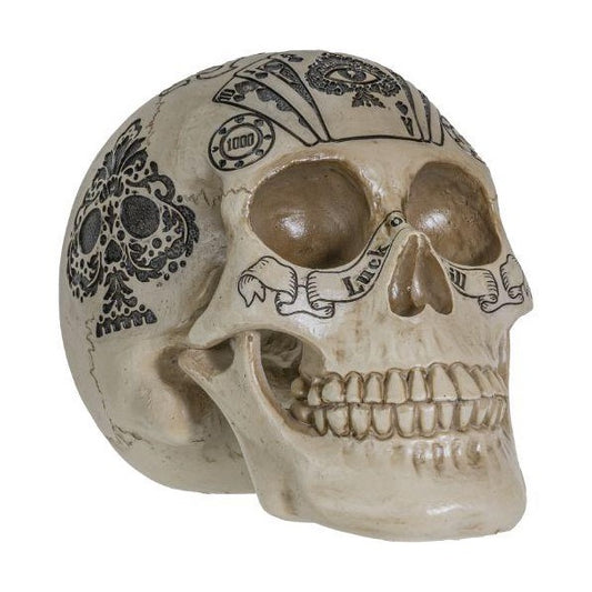 Decorative skull with intricate black tattoo-like designs.