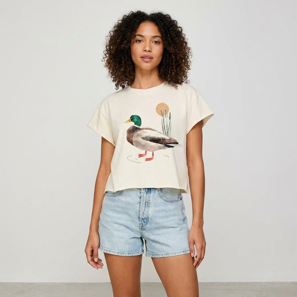 Woman in a duck print tee and denim shorts, standing confidently.