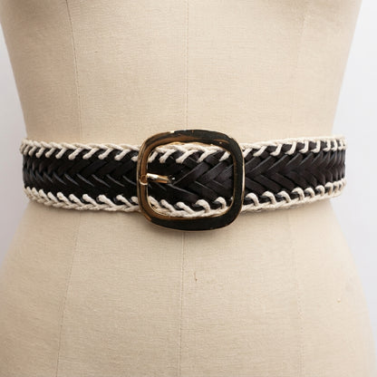Black and white woven belt with a gold buckle on a mannequin.