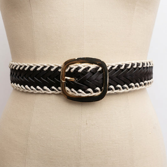 Black and white woven belt with a gold buckle on a mannequin.