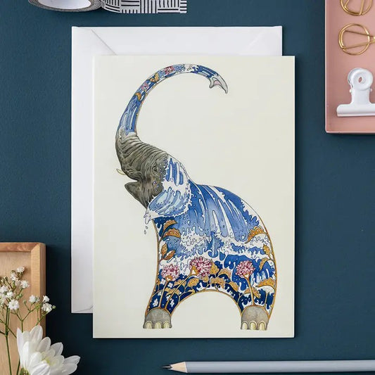 Artistic elephant card with intricate, colorful designs on a desk.