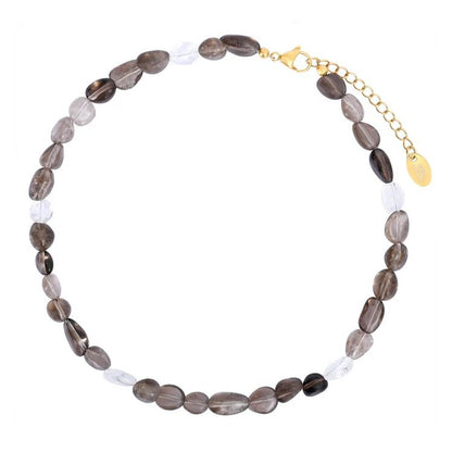 Necklace with oval, dark and clear beads, gold clasp and chain.